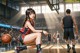 A woman sitting on the floor with a basketball in front of her.