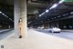 A naked woman standing in the middle of a parking garage.