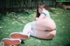 A woman in a blue and white outfit is sitting on the grass.