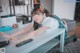 A woman sitting at a table with a remote control.