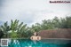 A woman in a swimming pool with trees in the background.