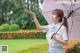 A woman in a school uniform holding an umbrella.